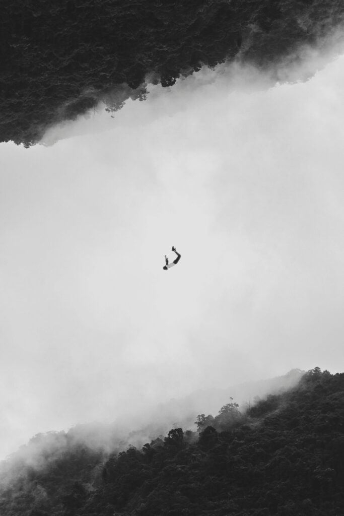 A person floating in a foggy, mirrored forest, symbolizing the emotional highs of love and the deep descent of heartbreak.