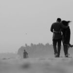 A black and white image of a couple walking closely, symbolizing emotional connection and relationship growth.