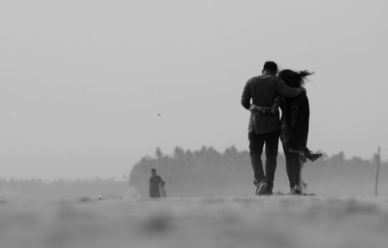 A black and white image of a couple walking closely, symbolizing emotional connection and relationship growth.